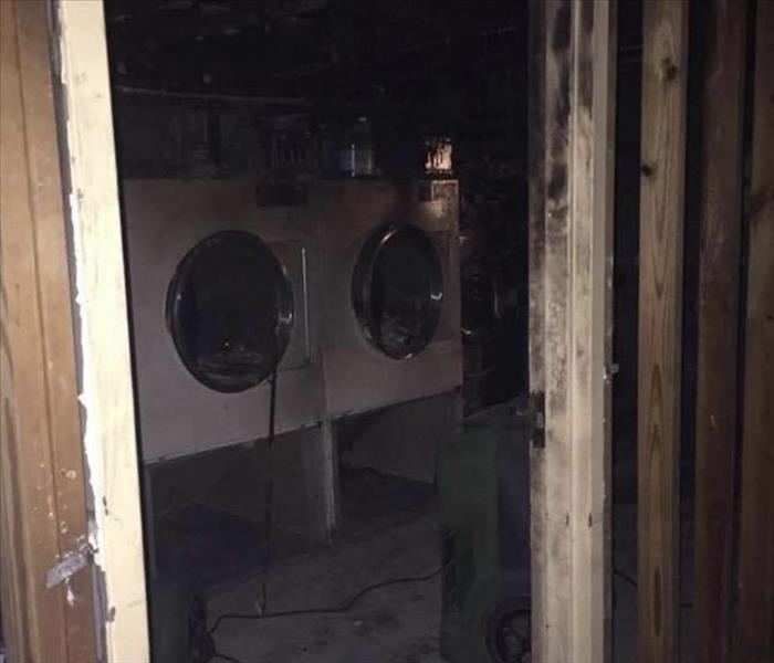 A laundry room that has fire damage is shown