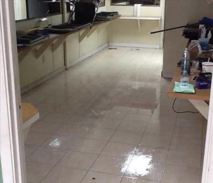 A room with water damage is shown with things stored off the floor