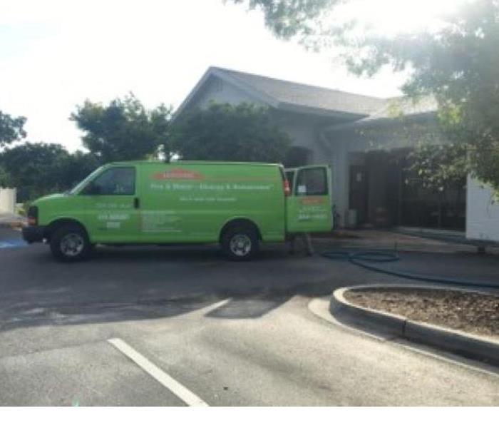 A green van is shown in front of a business